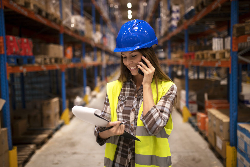 warehouse-worker-with-hardhat-having-conversation-phone-holding-checklist-distribution-warehouse-facility-1024x683